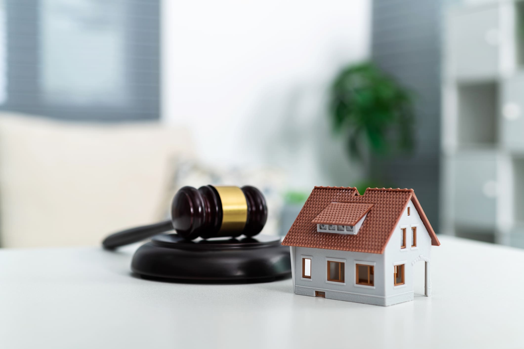 Gavel and house model: real estate law.